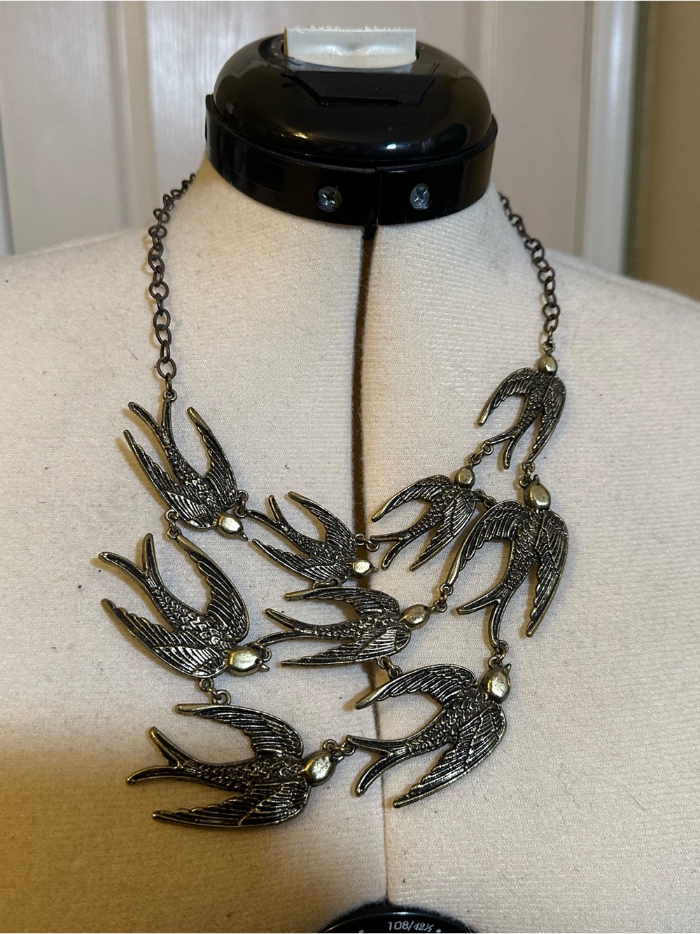 Vintage-Inspired Black and Gold Swallow Bib Necklace. Antique brass finish.